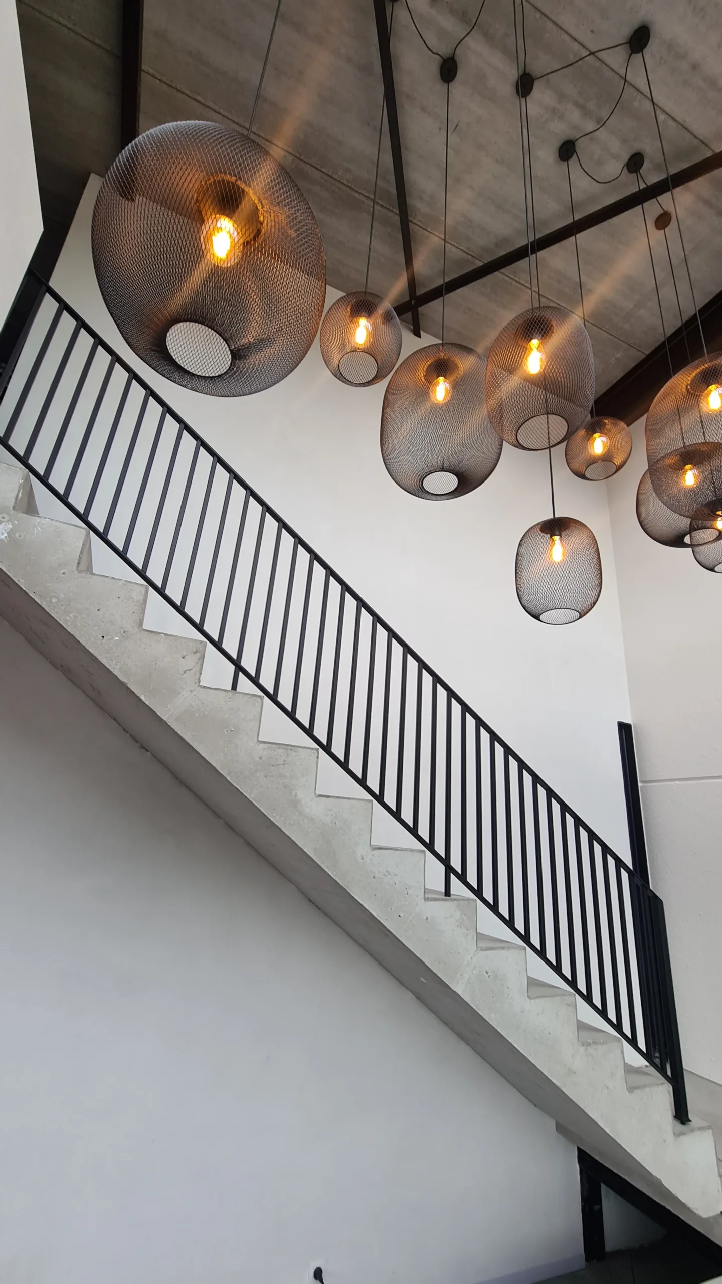 Architecturale trapleuning in zwart staal – JVH Welding Architecturale zwarte stalen trapleuning op betonnen trap, gerealiseerd door JVH Welding