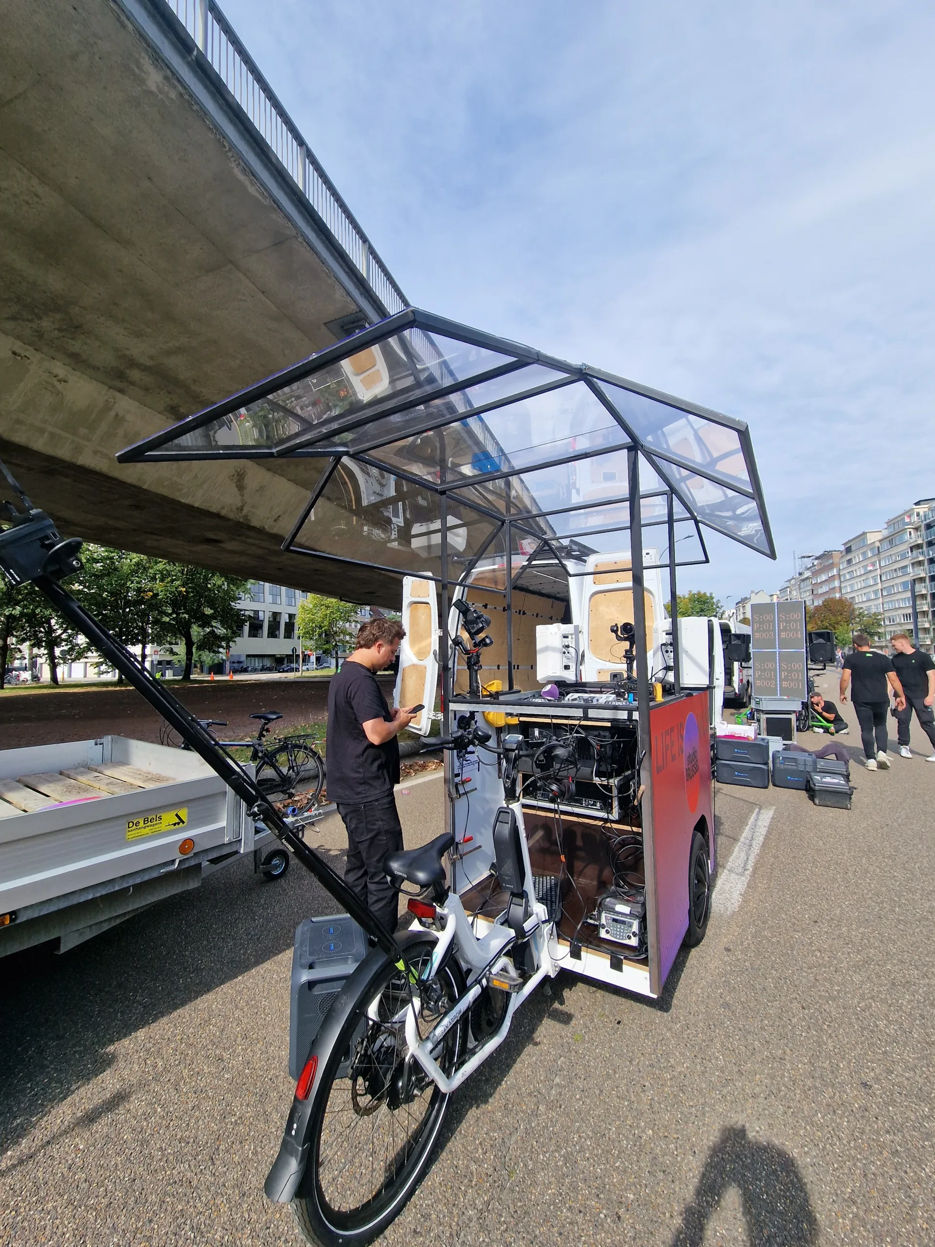 Fietsconstructie met openvouwbaar dak – maatwerk voor Studio Brussel Metalen fietsconstructie met openvouwbaar dak in zwart gepoederlakt staal, vervaardigd door JVH Welding voor Studio Brussel