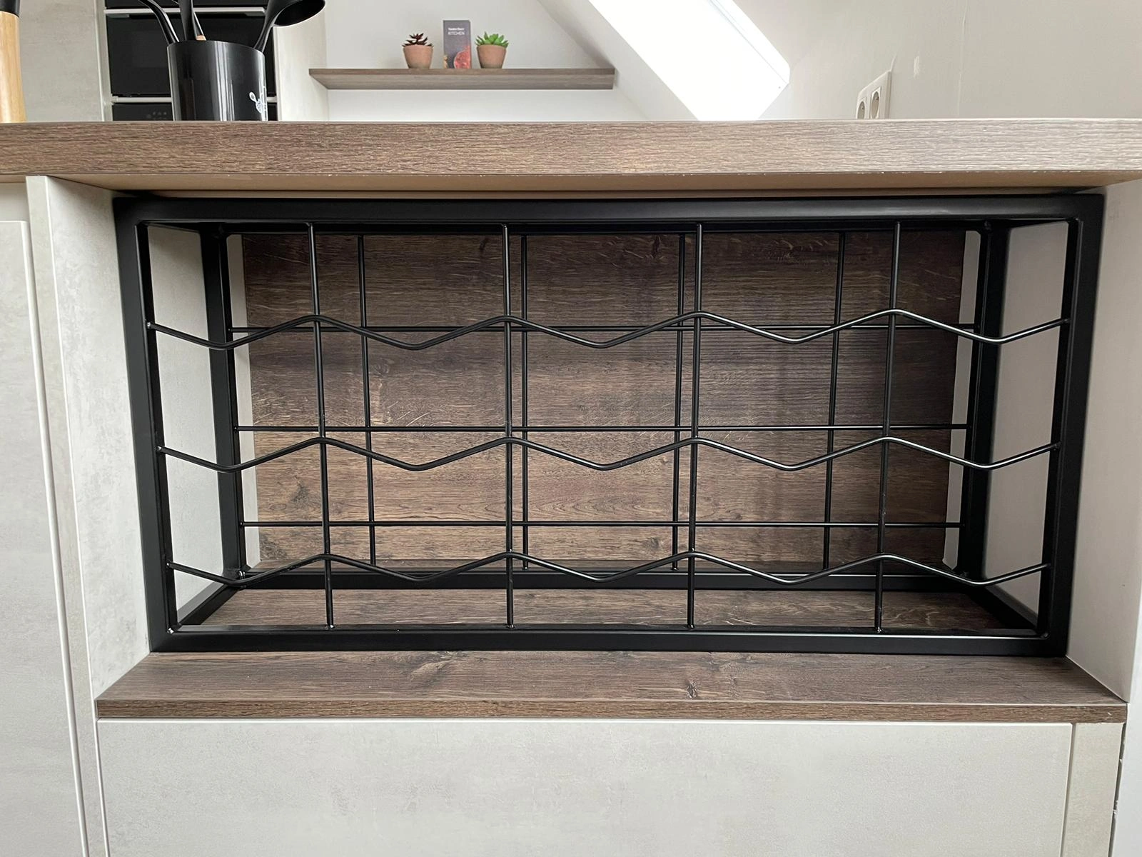 Wijnrek op maat in zwart gepoederlakt staal – stijlvol vakwerk van JVH Welding Op maat gemaakt wijnrek in zwart gepoederlakt staal, geïntegreerd in keuken – JVH Welding