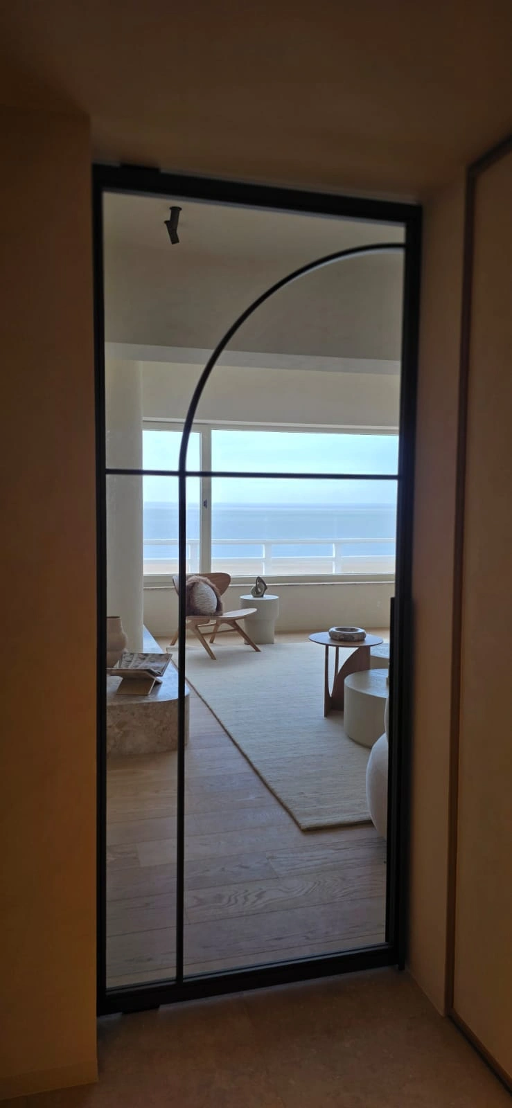Maatwerk stalen deur met geïntegreerde boogvorm in appartement aan zee, vervaardigd door JVH Welding.
